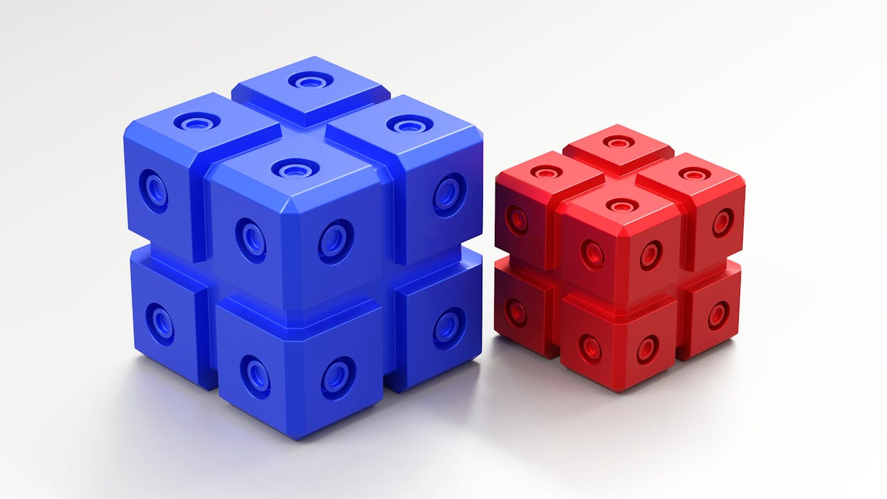 A vibrant render of geometric blue and red cubes with circular indentations on a white surface.